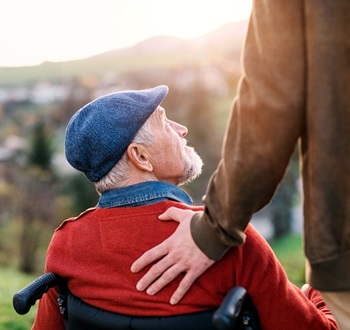 man in wheelchair with hand on shoulder